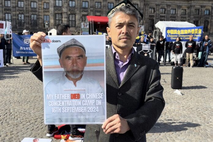 Abdurehim Gheni holds a poster of his father, Abdugheni Hudaberdi, on July 29, 2024, in Amsterdam during a protest against the Chinese government’s brutal policies in the Uyghur homeland. (Photo courtesy of Abdurehim Gheni.)